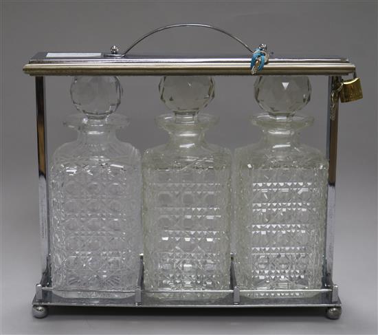 A 1930s chromed metal tantalus, fitted with three cut glass decanters, later padlock, 30cm
